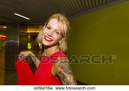 Stock Photo - Portrait of young woman wearing red dress in subway station. Fotosearch