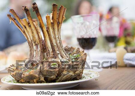 Rack of lamb on plate at family meal, close-up View Large Photo Image Stock Photo - Rack of lamb on plate at family meal, close-up. Fotosearch