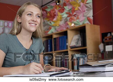 Sales assistant doing paperwork in stationery shop View Large Photo Image Stock Photo - Sales assistant doing paperwork in stationery shop. Fotosearch