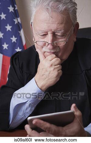 Senior judge reading digital tablet View Large Photo Image Stock Image - Senior judge reading digital tablet. Fotosearch