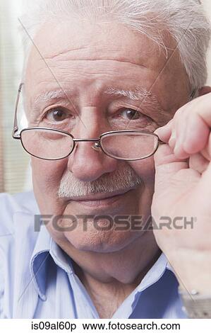 Stock Photography - Senior man looking over glasses. Fotosearch