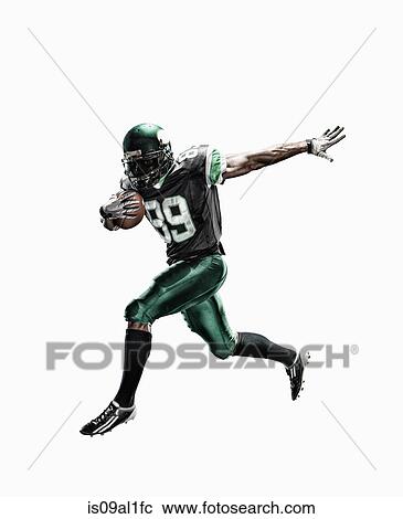 Studio shot of male football player running with ball View Large Photo Image Stock Image - Studio shot of male football player running with ball. Fotosearch