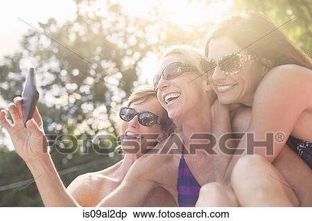 Three mature women in swimwear, taking self portrait View Large Photo Image Stock Photography - Three mature women in swimwear, taking self portrait. Fotosearch