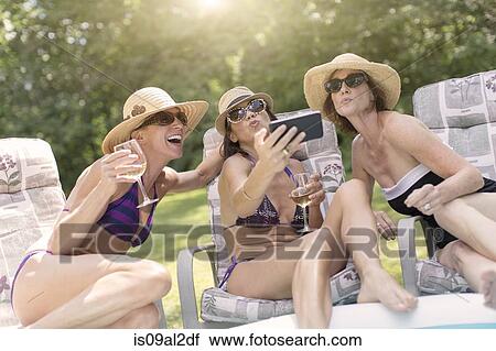 Three mature women taking self portrait using smartphone View Large Photo Image Stock Image - Three mature women taking self portrait using smartphone. Fotosearch