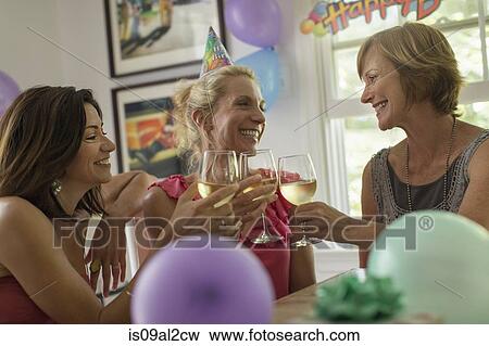 Stock Photo - Three mature women toasting with wine glasses. Fotosearch