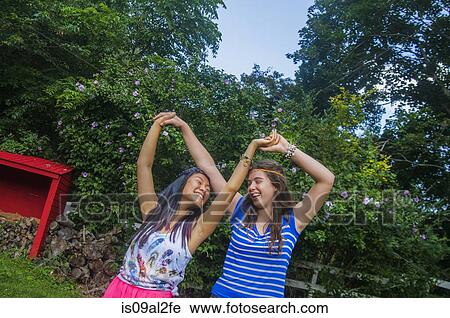 Stock Image - Two teenagers dancing, outdoors. Fotosearch