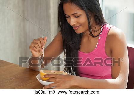 Woman eating grapefruit at home View Large Photo Image Stock Photo - Woman eating grapefruit at home. Fotosearch