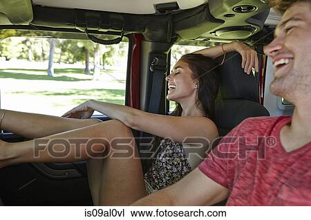 Stock Image - Young couple laughing in car. Fotosearch