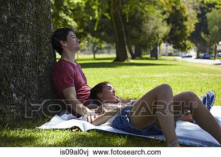 Stock Image - Young couple relaxing in park. Fotosearch