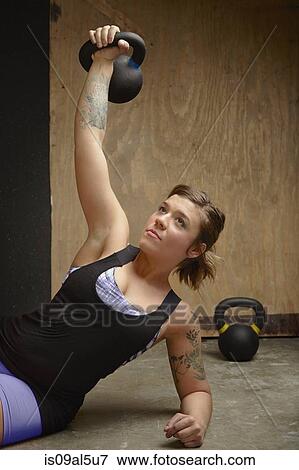 Young female crossfitter lifting kettlebell in gym View Large Photo Image Stock Photo - Young female crossfitter lifting kettlebell in gym. Fotosearch
