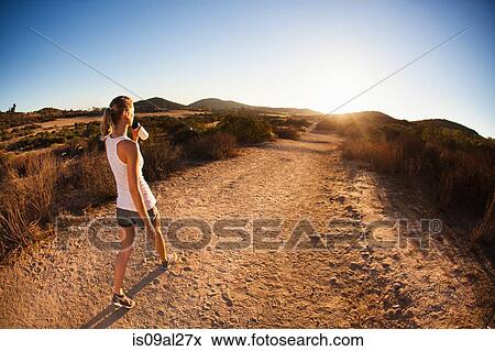 Young female jogger on path, drinking, Poway, CA, USA View Large Photo Image Stock Photo - Young female jogger on path, drinking, Poway, CA, USA. Fotosearch