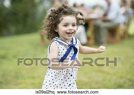 Stock Photography - Young girl running and playing at family gathering. Fotosearch