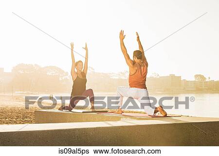 Stock Photograph - Young man and woman doing yoga on pier at Pacific beach, San Diego, California, USA. Fotosearch