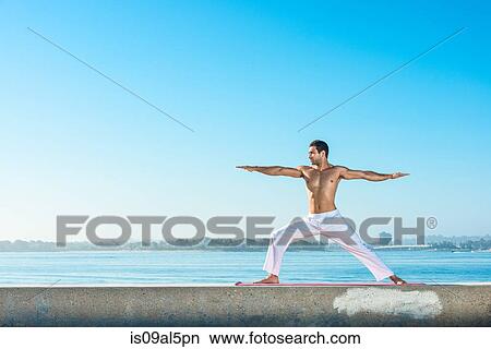 Young man practicing yoga position at Pacific beach, San Diego, California, USA View Large Photo Image Picture - Young man practicing yoga position at Pacific beach, San Diego, California, USA. Fotosearch