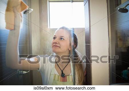 Picture - Young woman cleaning bathroom with green cleaning products. Fotosearch