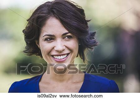 Stock Photo - Young woman in city park laughing. Fotosearch