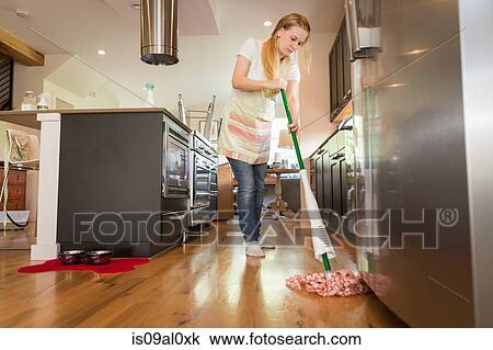Stock Image - Young woman mopping with green cleaning products. Fotosearch
