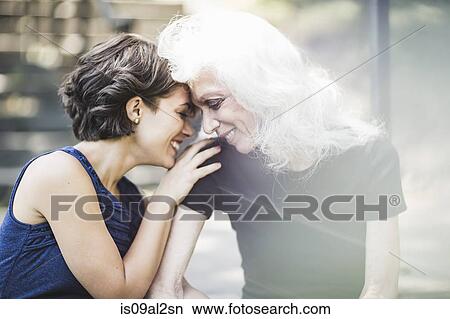 Picture - Young woman sharing tender moment with mentor. Fotosearch