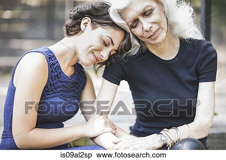 Stock Photography - Young woman sharing tender moment with mentor. Fotosearch