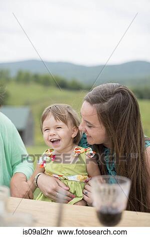 Young woman sitting with baby girl on her lap View Large Photo Image Stock Photography - Young woman sitting with baby girl on her lap. Fotosearch