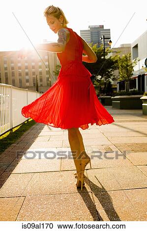 Young woman twirling whilst wearing red dress View Large Photo Image Stock Image - Young woman twirling whilst wearing red dress. Fotosearch