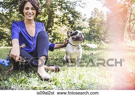 Young woman with dog in city park View Large Photo Image Stock Photograph - Young woman with dog in city park. Fotosearch