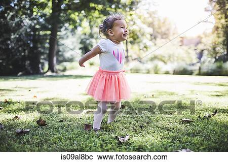 Stock Image - Baby girl playing in garden. Fotosearch