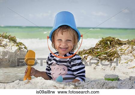 Baby girl with bucket over head on beach, Anna Maria Island, Florida, USA View Large Photo Image Stock Photo - Baby girl with bucket over head on beach, Anna Maria Island, Florida, USA. Fotosearch