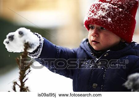 Close up of male toddler touching plant with snow covered glove View Large Photo Image Stock Image - Close up of male toddler touching plant with snow covered glove. Fotosearch