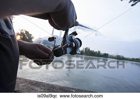 Stock Image - Close up of man fishing on river Raisin, Monroe, Michigan, USA. Fotosearch