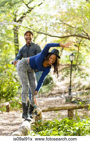 Couple balancing on garden edging View Large Photo Image Stock Photo - Couple balancing on garden edging. Fotosearch