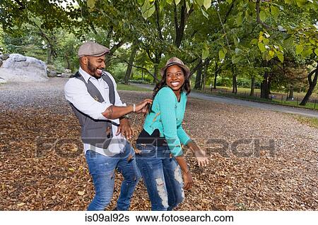 Couple playing with autumn leaves View Large Photo Image Stock Photograph - Couple playing with autumn leaves. Fotosearch