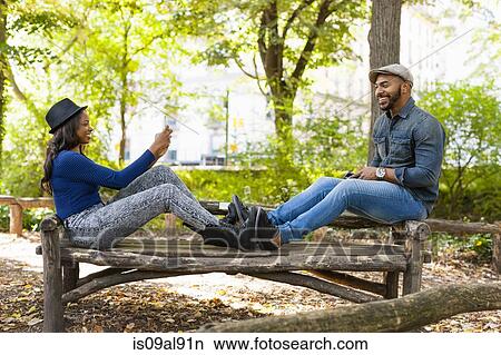 Couple taking photograph on bench, Central Park, New York, USA View Large Photo Image Picture - Couple taking photograph on bench, Central Park, New York, USA. Fotosearch