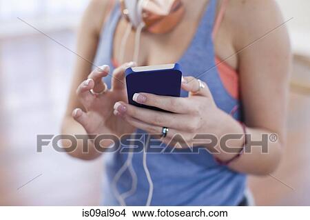Cropped shot of teenage girl using smartphone touchscreen in ballet school View Large Photo Image Picture - Cropped shot of teenage girl using smartphone touchscreen in ballet school. Fotosearch