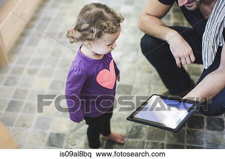 Father and daughter using digital tablet in kitchen View Large Photo Image Stock Photography - Father and daughter using digital tablet in kitchen. Fotosearch