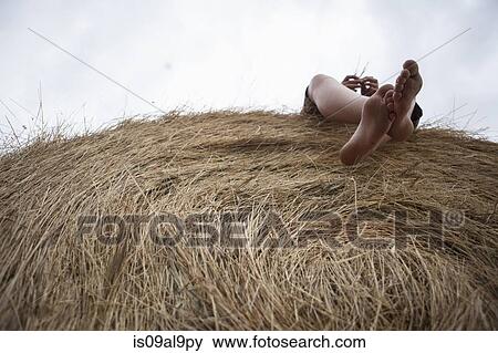 Feet of teenage boy lying on haystack, South Dakota, USA View Large Photo Image Stock Photo - Feet of teenage boy lying on haystack, South Dakota, USA. Fotosearch