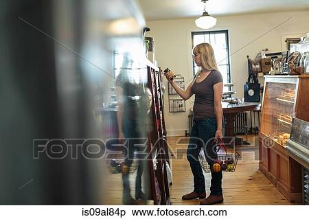 Female customer looking at tin can in country store View Large Photo Image Stock Photography - Female customer looking at tin can in country store. Fotosearch