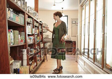 Female customer selecting from shelf in country store View Large Photo Image Stock Photograph - Female customer selecting from shelf in country store. Fotosearch