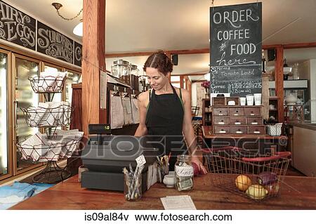 Female sales assistant using check out till in country store cafe View Large Photo Image Stock Photo - Female sales assistant using check out till in country store cafe. Fotosearch