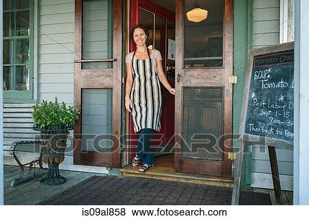 Female shop assistant in doorway of country store View Large Photo Image Stock Photo - Female shop assistant in doorway of country store. Fotosearch