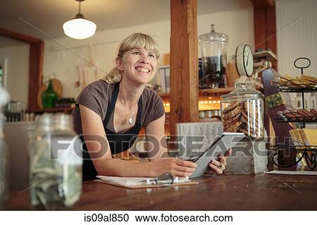 Female shop assistant with digital tablet in country store View Large Photo Image Stock Image - Female shop assistant with digital tablet in country store. Fotosearch