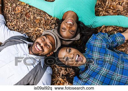 Friends lying on fallen autumn leaves View Large Photo Image Stock Photography - Friends lying on fallen autumn leaves. Fotosearch