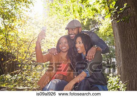 Stock Photograph - Friends taking selfie. Fotosearch