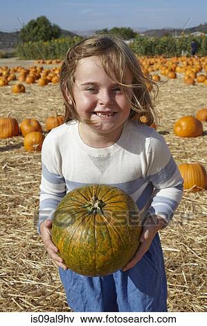Stock Photo - Girl carrying pumpkin. Fotosearch