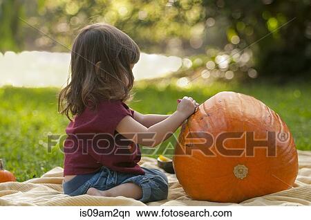 Girl drawing on pumpkin View Large Photo Image Picture - Girl drawing on pumpkin. Fotosearch