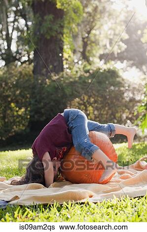 Stock Photograph - Girl lying on pumpkin. Fotosearch