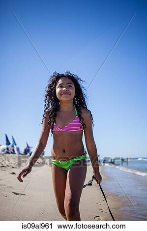 Stock Image - Girl strolling on beach with seaweed, Truro, Massachusetts, Cape Cod, USA. Fotosearch