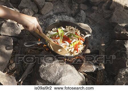 Hand of teenage boy cooking stir fry on campfire, Indiahoma, Oklahoma, USA View Large Photo Image Stock Image - Hand of teenage boy cooking stir fry on campfire, Indiahoma, Oklahoma, USA. Fotosearch