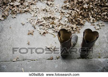 Stock Image - High angle view of a pair of cowboy boots on step. Fotosearch