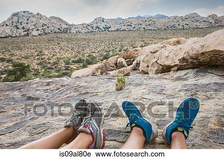 Stock Image - Hikers taking break on mountain, Joshua Tree National Park, California, US. Fotosearch